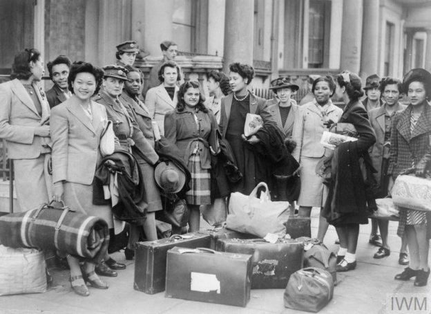 A group of West Indian women recruited to join the ATS wait for transport to take them to their training camp, 10 November 1943. Imperial War Museum AP 14372D, 1943