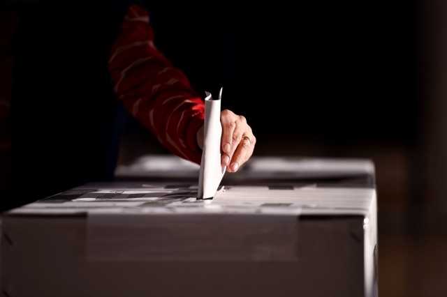 Hand of a person casting a vote into the ballot box. Shutterstock photo ID: 533906236