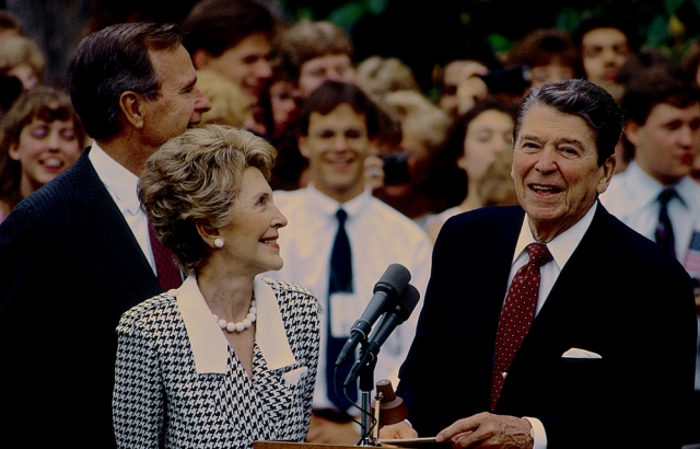 Washington, DC., USA, June 3, 1987 President Ronald Reagan and First Lady Nancy Reagan along with Vice-President Goerge H.W. Bush at podium on South lawn of the White House prior to departure on trip. Shutterstock Image ID: 1058206553
