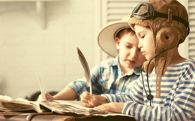 Children in historical costume writing with quills