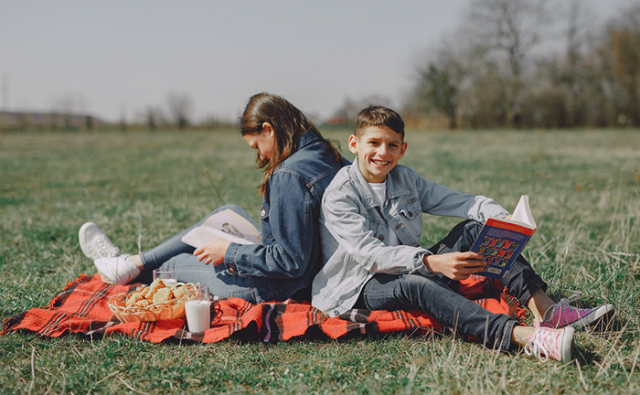 Sister and brother reading in park. Photo by Gustavo Fring from Pexels