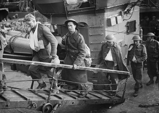 Wounded British soldiers evacuated from Dunkirk make their way up the gangplank from a Destroyer at Dover, 31 May 1940