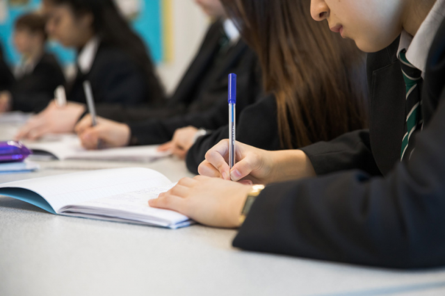Secondary students writing in history class